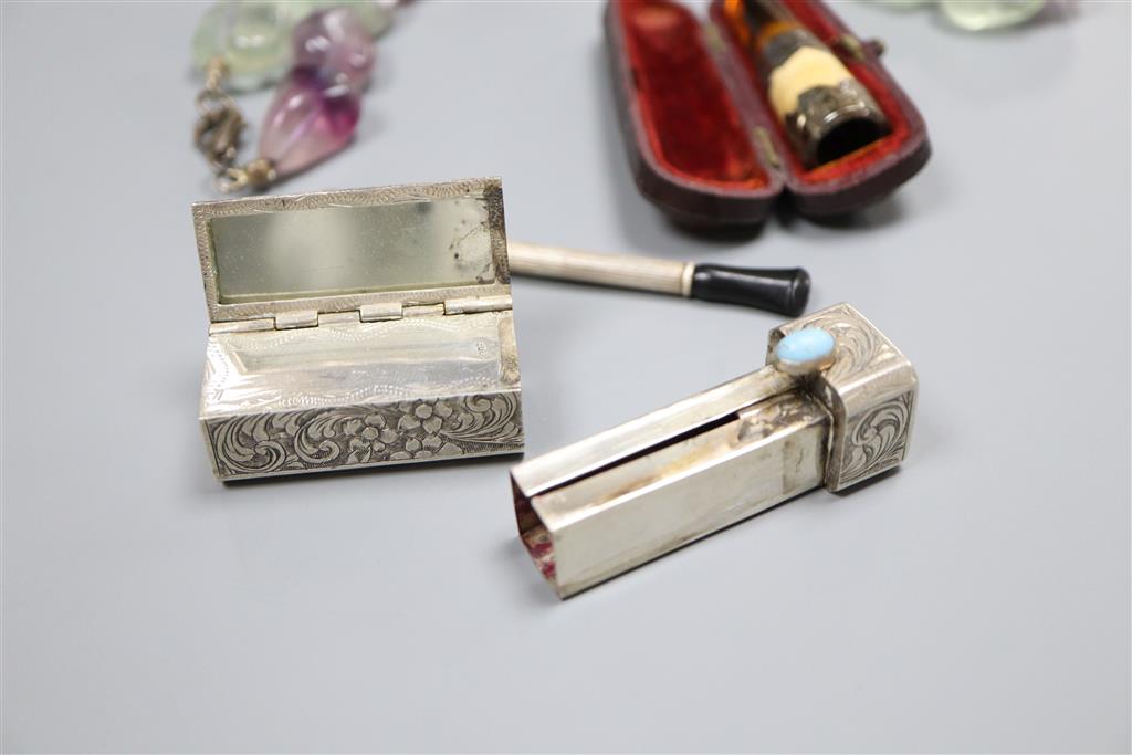 Two white metal cigarette holders, an 800 lipstick holder and a quartz necklace.